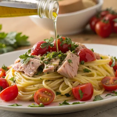 Tuna pasta dish with cherry tomatoes, fresh parsley, olive oil, elegant plating, professional food photography, warm natural